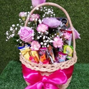 Cesta de regalo con mix de flores de colores varios y confituras.